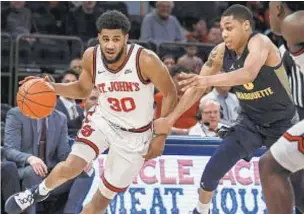  ?? AP ?? St. John's guard LJ Figueroa drives to the basket around Marquette guard Greg Elliott on Saturday afternoon at the Garden.