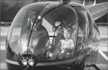  ?? NWA Democrat-Gazette/CHARLIE KAIJO ?? August Wagner and Greyson Wagner, 5, of Bella Vista (right) ride a helicopter Saturday at the Arvest Ballpark in Springdale.