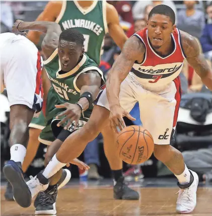  ?? GEOFF BURKE / USA TODAY SPORTS ?? Bucks guard Tony Snell and Wizards guard Bradley Beal battle for a loose ball Monday in Milwaukee’s 107-102 loss at the Verizon Center.