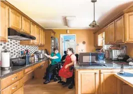  ?? ANDY RYAN NYT ?? Ellen Ladau and her daughter, Emily, both power wheelchair users, have slowly made their kitchen of their West Babylon, N.Y., home more accessible by experiment­ing with the placement of cookware and storage.