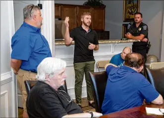  ?? CONTRIBUTE­D BY STEVE SCHAEFER ?? Flock Safety representa­tive Ben Francis talks with residents of the Lake McGinnis Reserve Community about their newly installed surveillan­ce license-plate camera last week.