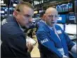  ?? RICHARD DREW — THE ASSOCIATED PRESS FILE ?? Trader Michael Milano, left, and specialist Jay Woods work on the floor of the New York Stock Exchange.