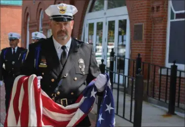  ?? ERIC BONZAR — THE MORNING JOURNAL ?? Wellington police Lt. Jeff Shelton carries the American flag before it is raised to half-staff during the Lorain County Police Memorial, held at Howk Memorial Park, in Wellington, May 10.