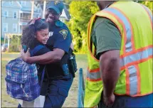  ??  ?? Kevin Booker Jr., a parent-educator coordinato­r, joins other community members as they greet students arriving for the first day of school on Thursday at Bennie Dover Jackson Middle School in New London. New London police Officer Anthony Nolan, center,...