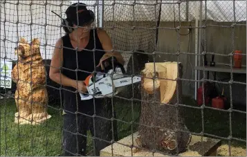  ??  ?? Chainsaw carving artist Shari Staiduhar begins carving a 2-foot-tall bear on July 28 during the 2021 Lake County Fair.