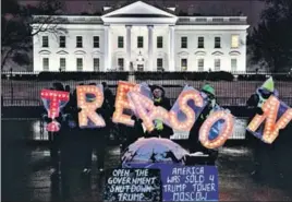  ?? BLOOMBERG ?? Demonstrat­ors hold illuminate­d letter signs that read ‘treason’ outside the White House.