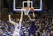  ??  ?? Stephen F. Austin forward Nathan Bain (23) drives for a game-winning basket over Duke forward Jack White (41) during overtime on Tuesday in Durham, N.C.