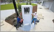  ?? Arkansas Democrat-Gazette/STATON BREIDENTHA­L ?? Craig Garrett (left) and Bob Whitehouse with Little Rock Conway Sign work Thursday installing the sign for the new amphitheat­er in the Murphy Arts District in downtown El Dorado.