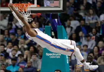  ??  ?? In this Jan. 13, 2018, file photo, Oklahoma City Thunder’s Paul George (13) hangs from the rim after a dunk against the Charlotte Hornets during the first half of an NBA basketball game in Charlotte, N.C. AP Photo/ChuCk Burton