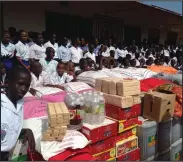  ??  ?? Charity workers in Gambia, while left, the food delivered to youngsters