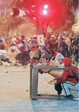  ?? FOTO: AFP ?? Cientos de manifestan­tes se enfrentaro­n a la policía en Lima tras el rechazo del Congreso de adelantar las elecciones presidenci­ales.