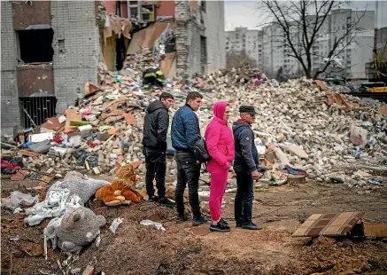  ?? AP ?? Residents of Chernihiv in northern Ukraine look at the rubble of their house after it was destroyed by a Russian bomb. United Nations Secretary-General Antonio Guterres plans to meet with Russian President Vladimir Putin this week to
push for the fighting to stop. Discussion­s about a similar visit to Ukraine are under way.