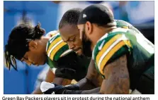  ?? STACY REVERE / GETTY IMAGES ?? Green Bay Packers players sit in protest during the national anthem before the game against the Cincinnati Bengals at Lambeau Field on Sunday in Green Bay, Wis.