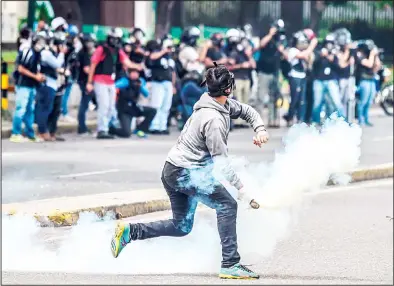  ??  ?? An opposition activist clashes with the police during a march towards the Supreme Court of Justice (TSJ) in an offensive against President
Maduro and his call for Constituen­t Assembly in Caracas on July 22. (AFP)
