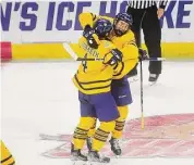  ?? Brian A. Pounds/Hearst Connecticu­t Media ?? Quinnipiac’s Michael Lombardi, left, is hugged by teammate Jake Johnson after scoring a goal in the third period of a 5-0 victory over Merrimack in a Division I tournament regional game at the Total Mortgage Arena in Bridgeport on Friday.