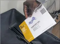  ?? PHOTO BY PAUL BERSEBACH — ORANGE COUNTY REGISTER/SCNG ?? A poll worker puts a mail-in ballot in a security box in the recall election of Gov. Gavin Newsom at a center in San Clemente, CA on Tuesday, September 7, 2021.