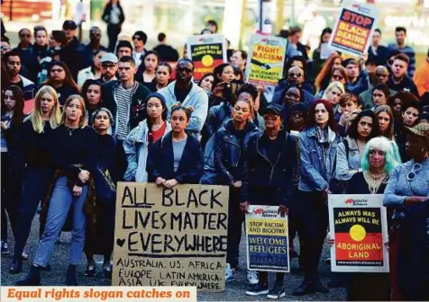  ?? AFP ?? People hold up banners at a Black Lives Matter rally in Sydney yesterday. Some 300 people gathered to demonstrat­e against racism in Australia and elsewhere, as racial tensions in the US simmer over the killing of black men by police.