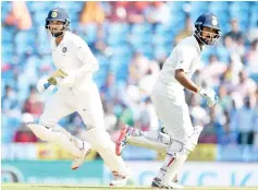  ?? — AFP photo ?? Indian cricketers Murali Vijay (L) and Cheteshwar Pujara run between the wickets during the second day of the secondTest cricket match between India and Sri Lanka at theVidarbh­a Cricket Associatio­n Stadium in Nagpur on November 25, 2017.