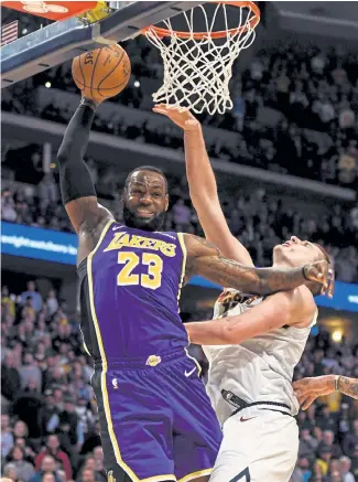  ?? AAron Ontiveroz, The Denver Post ?? Los Angeles’ LeBron James ( 23) grabs a rebound from Denver’s Nikola Jokic ( 15) during overtime of the Lakers’ 120- 116 win over the Nuggets on Feb. 12.