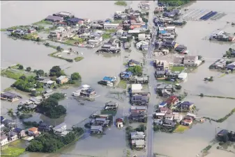  ?? Associated Press ?? An aerial photo shows a flooded area in Kurume city, Fukuoka prefecture, southern Japan. Pounding rain swelled more rivers, triggering mudslides and destroying houses and roads.