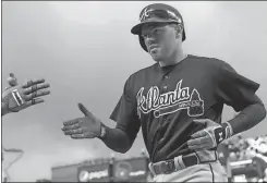  ?? Jim Mone / The Associated Press ?? Atlanta’s Freddie Freeman is welcomed at the dugout after his two-run home run off Minnesota Twins pitcher Michael Tonkin during Wednesday’s game.