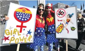  ??  ?? Protesters in Los Angeles show symbols of female empowermen­t Saturday on the one-year anniversar­y of the first women’s march.