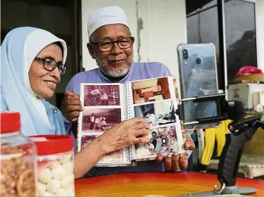  ??  ?? Down memory lane: yussoff and Wan Chah viewing old photos with their children through video call at their home in Balik Pulau, Penang.