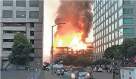  ?? AP ?? A large fire burns at a building under constructi­on on Friday in Oakland, Calif. The fire broke out around dawn Friday at a seven-story building under constructi­on.