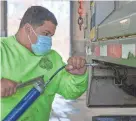  ?? DAVE ZAJAC/RECORD-JOURNAL VIA AP ?? Maintainer Juan Velazquez prepares a snowplow for service at the Meriden (Conn.) Public Works garage Monday.