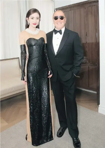  ??  ?? Chinese actress and model Yang Mi poses with designer Michael Kors at the 2017 Met Gala. Mi was recently named an “ambassador” for the Michael Kors brand, which has released a Sloan leather chain wallet, below left, $228, and gold-tone dog pin, below...