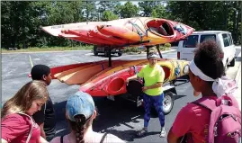  ?? NWA Democrat-Gazette/FLIP PUTTHOFF ?? Chelsea Porter, interprete­r at Hobbs State Park, shows youngsters the kayaks they will use.