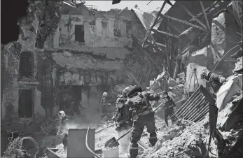  ?? AP PHOTO ?? Emergency workers clear rubble Thursday at the damaged Mariupol theater during heavy fighting in Mariupol, in territory under the government of the Donetsk People’s Republic, eastern Ukraine.