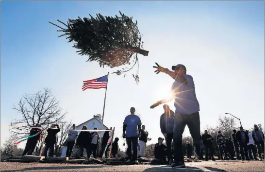  ?? [ERIC ALBRECHT/DISPATCH] ?? Andy Brougher of Springfiel­d takes part in the first-ever Christmas tree toss held by the Westervill­e Area Civitan Club to raise money for special needs kids.