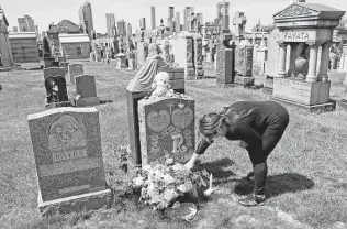  ?? Kathy Willens / Associated Press file photo ?? Sharon Rivera adjusts flowers and other items at the grave of her daughter, Victoria, at Calvary Cemetery in New York, on Mother’s Day in 2020. Victoria died of a drug overdose in 2019 at 21.