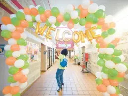  ?? KYLE TELECHAN/POST-TRIBUNE ?? Chelsea Whittingto­n, CEO of C Whitt PR, takes photos under a welcome sign at the YWCA of Northwest Indiana during the building’s first day of opening after its COVID-19 closures on June 15, 2020.