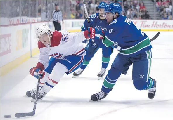  ?? — THE CANADIAN PRESS ?? Vancouver Canucks defenceman Derrick Pouliot fights for control of the puck with Montreal Canadiens left wing Daniel Carr during the first period on Tuesday night at Rogers Arena. Carr was one of six Habs to record a goal in the 7-5 Canucks loss.