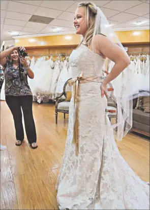  ?? By Robert Hanashiro, USA TODAY ?? Pinterest bride: Trish Smith tries on a wedding dress she found onlinevia Pinterest at Mary Me Bridal inOrange, Calif., as mom Phyllis Smithtakes a snapshot. Her wedding is setfor November.