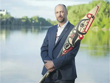  ?? NARDELLA PHOTOGRAPH­Y ?? Ry Moran, a member of the Red River Métis in Manitoba, holds a reconcilia­tion paddle carved by Carey Newman. Moran will take on a newly created role in the fall as UVic reconcilia­tion librarian.