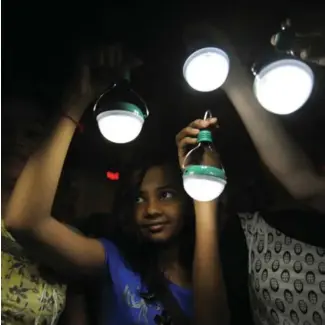  ?? PUNIT PARANJPE/AFP/GETTY IMAGES ?? Indian girls hold solar-powered lamps at a gathering to mark Earth Hour in Mumbai. Since it began in Sydney in 2007, Earth Hour has grown to include nearly 6,500 cities worldwide.