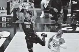  ??  ?? Memphis Grizzlies forward Brandon Clarke (15) dunks ahead of Phoenix Suns guard Chris Paul (3) in the first half Monday. [AP PHOTO/BRANDON DILL]