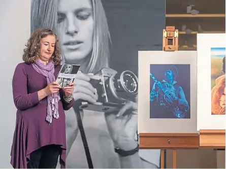  ??  ?? Fiona Hayes, curator at Glasgow museums, with photograph­s of the late Linda McCartney kindly donated by her husband Paul.