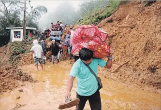  ?? JAYJAY LANDINGIN THE ASSOCIATED PRESS ?? Families and relatives of miners in Itogon in the northern Philippine­s flee from their homes after landslides buried an unknown number of miners.