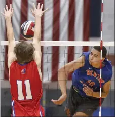  ?? PAUL CONNORS / BOSTON HERALD ?? GOING FOR THE KILL: Newton South’s Jaidin Russell, right, hits the ball between the outstretch­ed arms of Natick’s Branch Barnes in the Lions’ 3-2 win on Saturday.