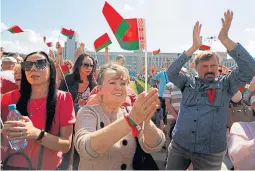  ??  ?? Supporters of President Alexander Lukashenko, pictured above, wave Belarusian State flags during a rally at the Independen­t Square of Minsk.