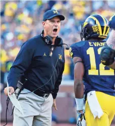  ?? RICK OSENTOSKI, USA TODAY SPORTS ?? Coach Jim Harbaugh, talking to running back Chris Evans, has led Michigan to four dominant victories this season.