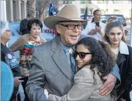  ?? L.E. Baskow Las Vegas Sun ?? NEVADA RANCHER Cliven Bundy hugs Maysoun Fletcher, an attorney for his son Ryan, in front of the Las Vegas Metropolit­an Police Department last week.