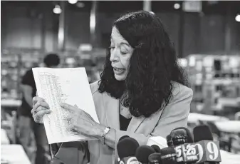  ?? Michele Eve Sandberg / AFP/Getty Images ?? Susan Bucher holds up the vote tallies at the Palm Beach County Supervisor of Election Warehouse. Final results have yet to be declared in multiple races following last week’s midterm polls, with tense recounts underway in Florida.