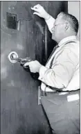  ??  ?? Steve Sumner, a MilkWagon Drivers’ Union Local 753 boss, demonstrat­es the security measures of the steel door at his union’s offices in 1932.