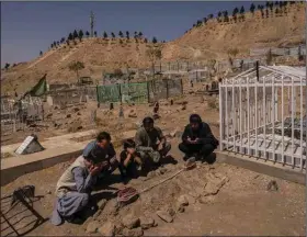  ?? (AP/Bernat Armangue) ?? The Ahmadi family prays Monday at the cemetery next to the graves of family members killed by a U.S. drone strike last month in Kabul, Afghanista­n. The family is demanding that Washington investigat­e who fired the drone and punish the military personnel responsibl­e.