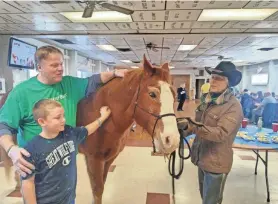  ?? JOHN CIANCI ?? Tom Vekeman, a Citizens Bank volunteer, and 9-year-old Jaxson Atkinson meet one of the Medicine Horse “therapists,” brought into the Tiverton VFW by Carol Ann Silva, right.